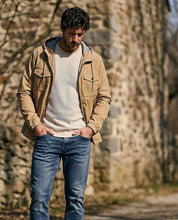 Poly Memory Safari Jacket with Hood in Kelp worn by a man outdoors, showcasing lightweight and stylish design.