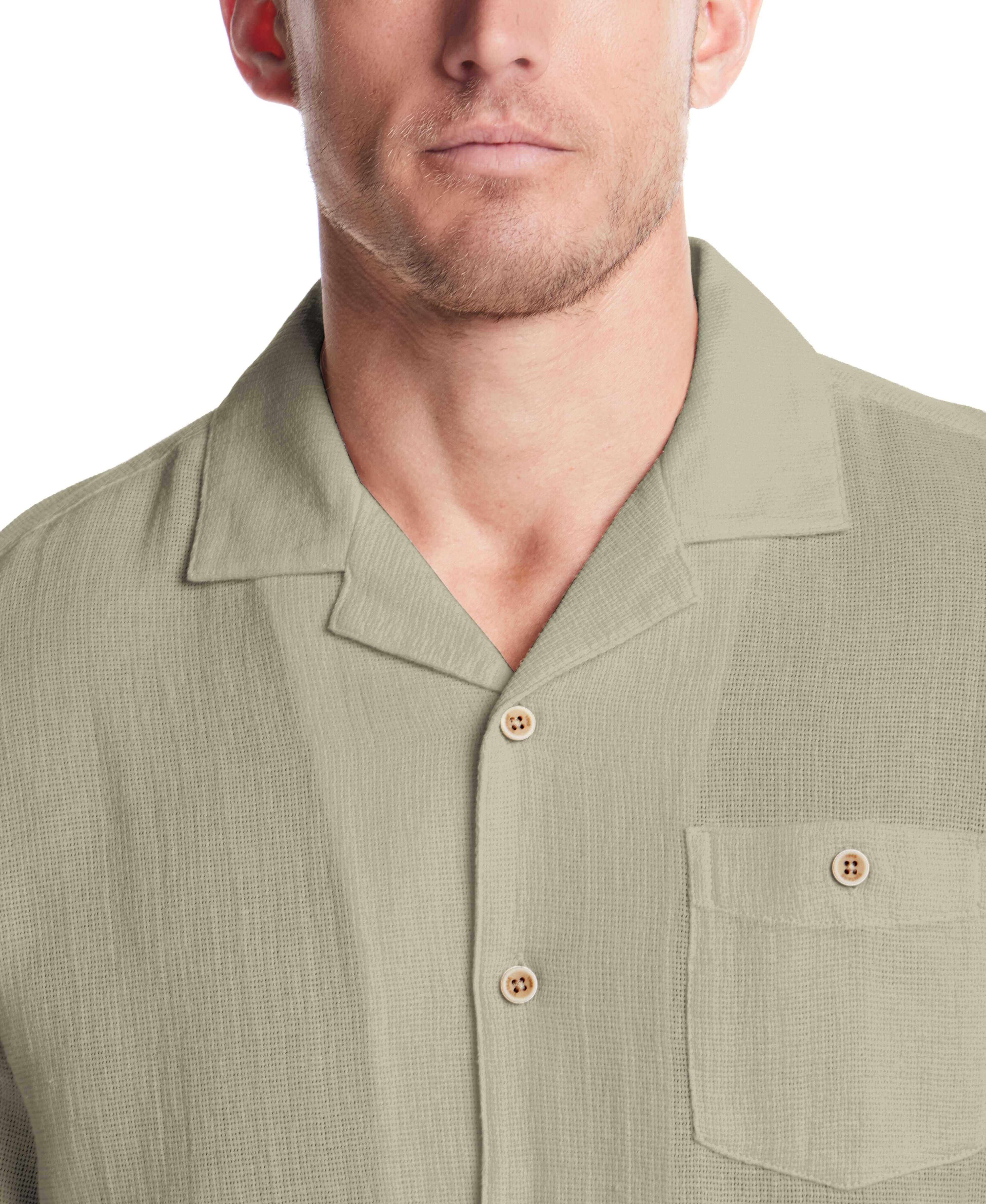 Close-up of a man wearing a Short Sleeve Cotton Linen Airtex Shirt in Sea Grass with a camp collar and button-down pocket.