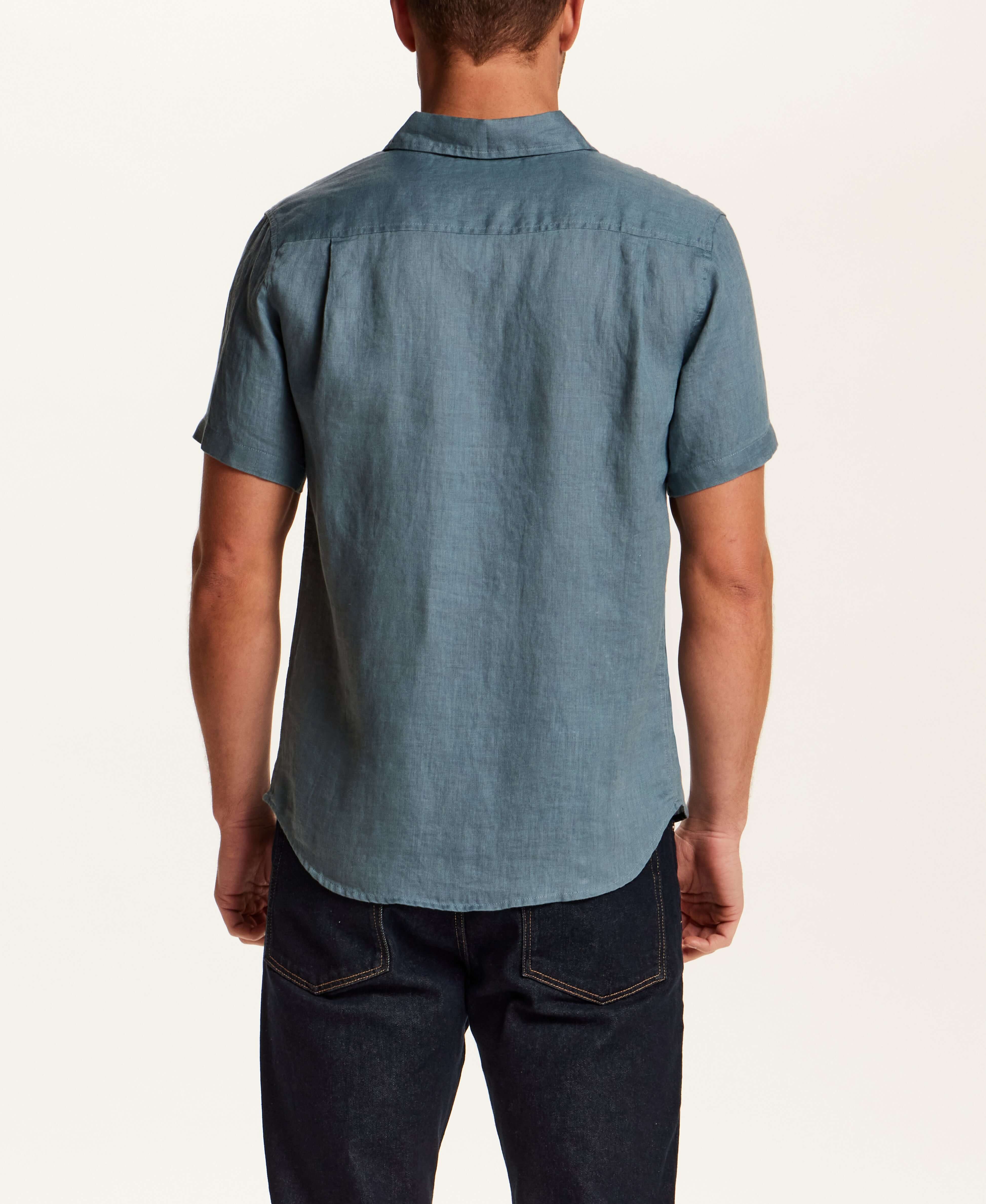 Back view of a man wearing a Short-Sleeve Linen Shirt in Blue, showcasing its relaxed fit and spread collar.
