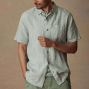 Short Sleeve Linen Shirt in Teal Mist worn by a man with a button closure and front pocket, showcasing its classic fit.