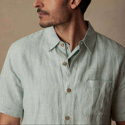Short Sleeve Linen Shirt in Teal Mist worn by a model showing collar and chest pocket in natural light.
