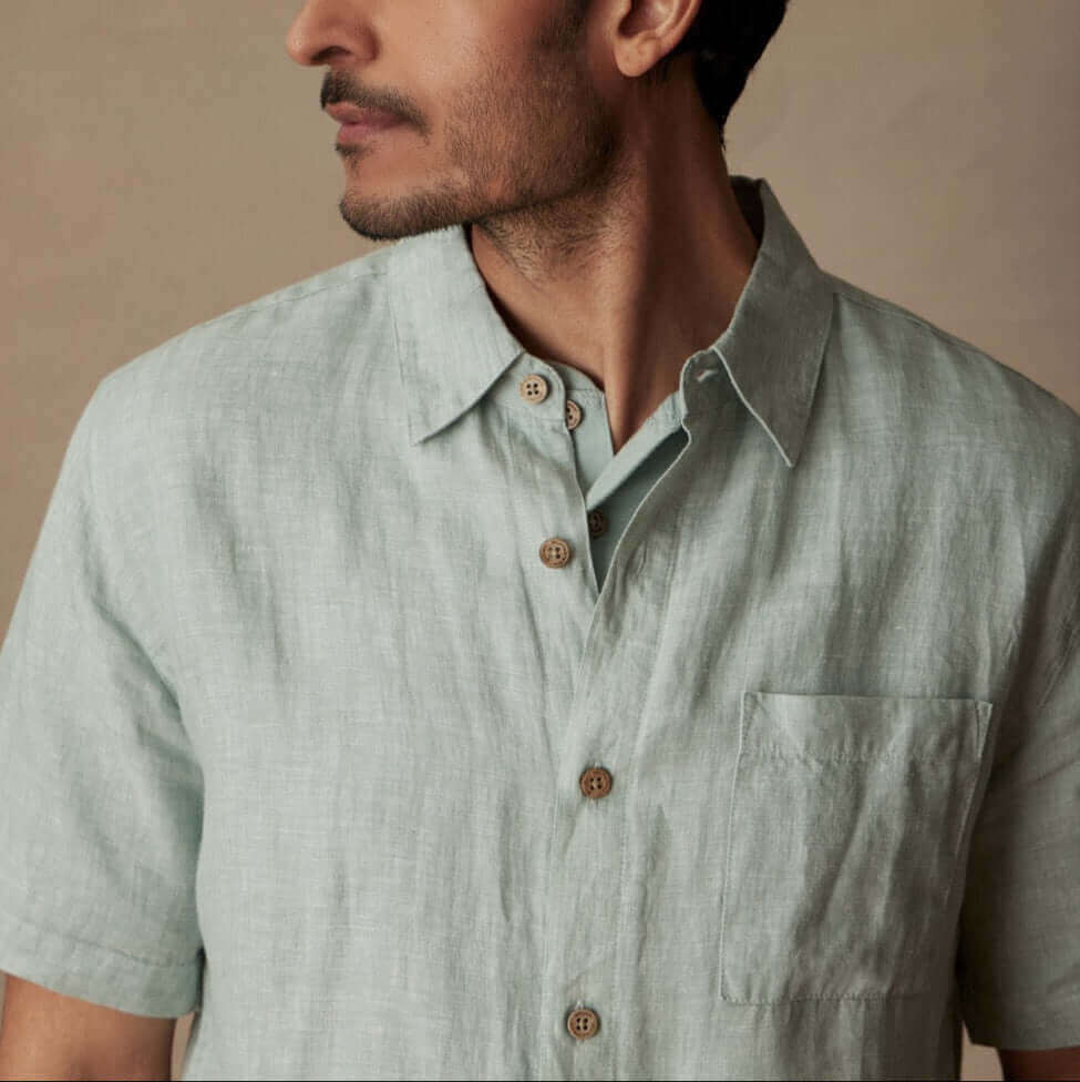 Short Sleeve Linen Shirt in Teal Mist worn by a model showing collar and chest pocket in natural light.