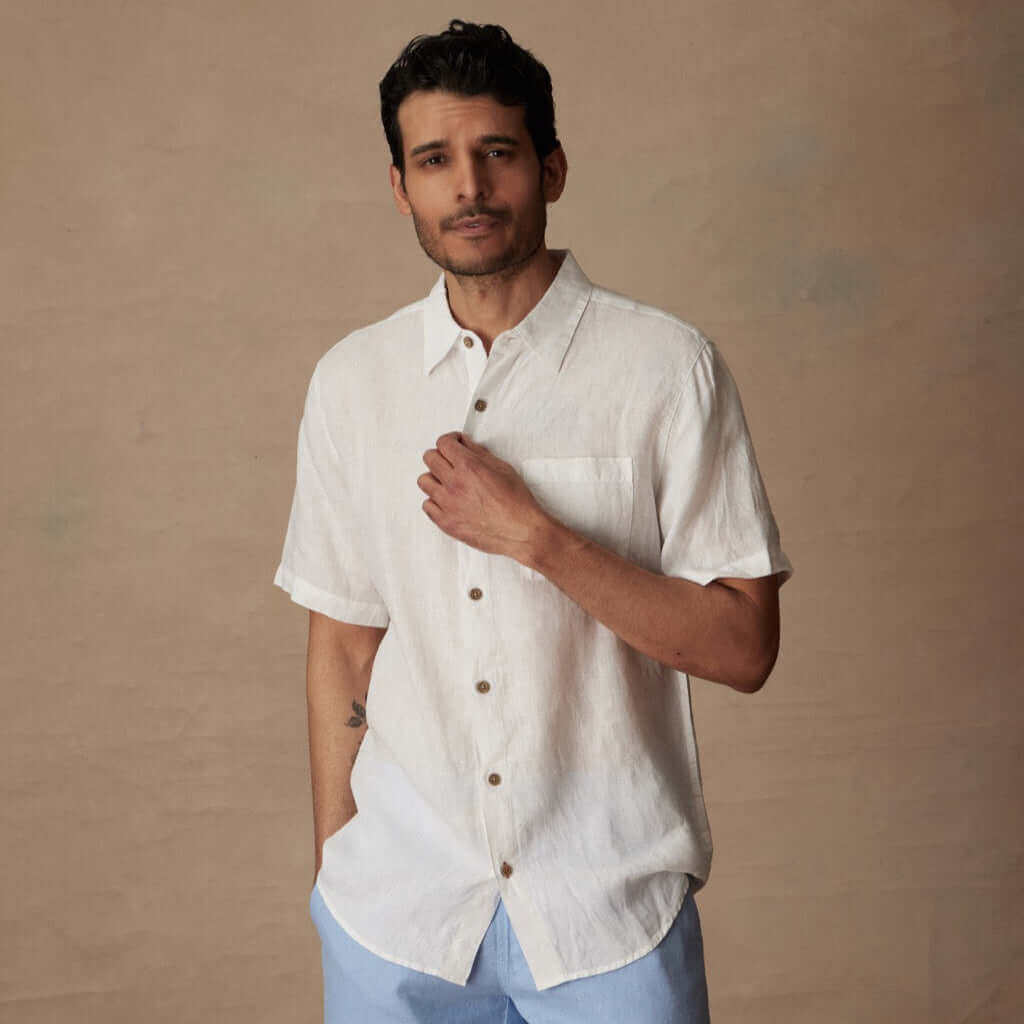 Model wearing a Short Sleeve Linen Shirt in White with a collar, button closure, and front pocket.