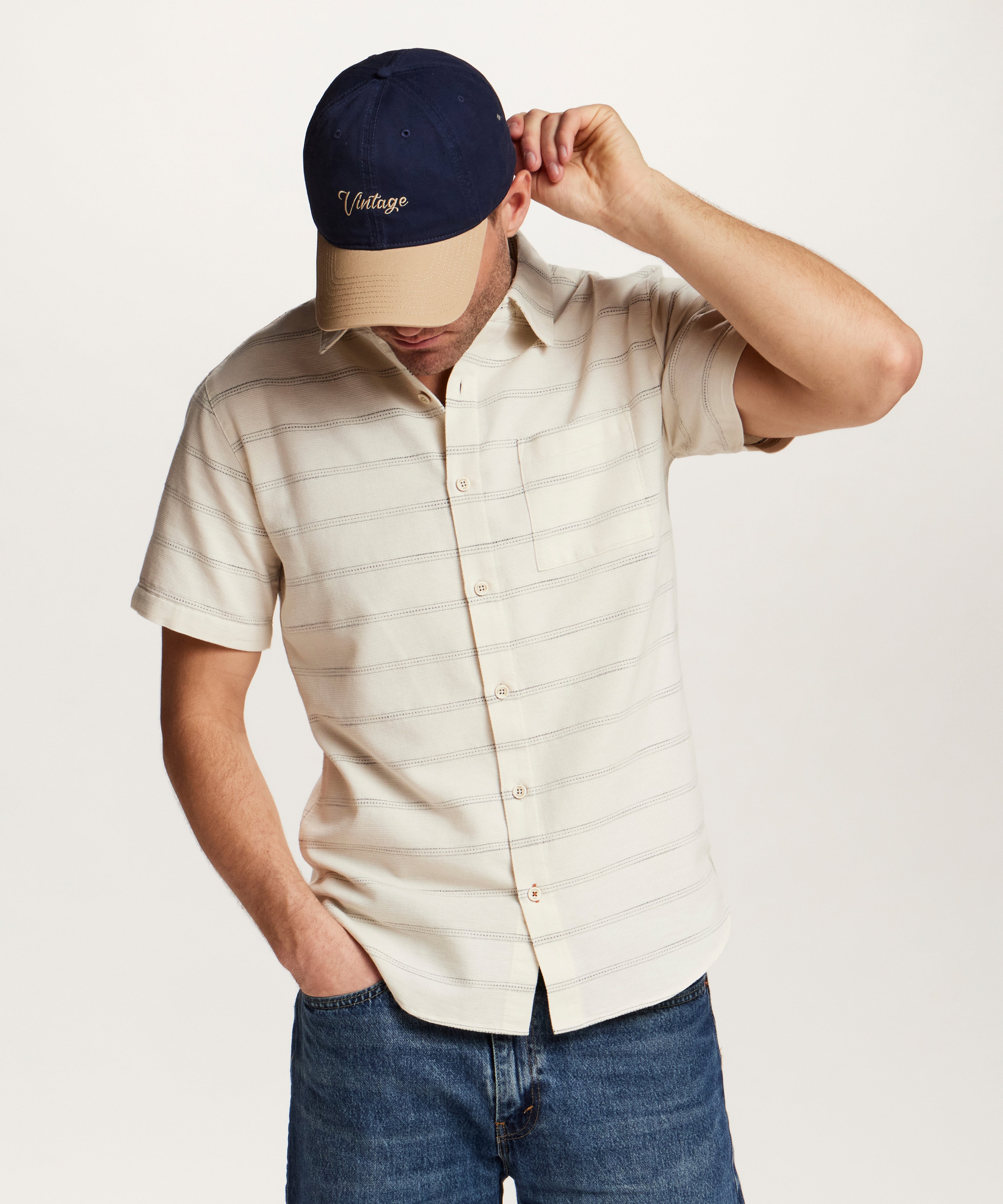 Textured Horizontal Stripe Button-Down Shirt in Turtle Dove modeled by a man wearing a cap and denim.