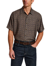 Model showcasing a Petal Print Short-Sleeve Shirt with a relaxed fit and button front, styled with dark jeans.