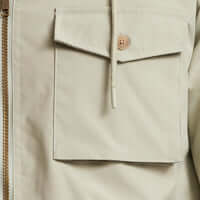 Close-up view of the pocket detail on the Poly Memory Safari Jacket with Hood in Sea Grass.