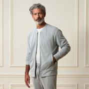 Mini Herringbone Bomber Jacket in Natural modeled by a man with grey hair, wearing a relaxed fit zip-up style.