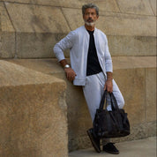 Model wearing Mini Herringbone Bomber Jacket in Natural with matching pants and a bag.