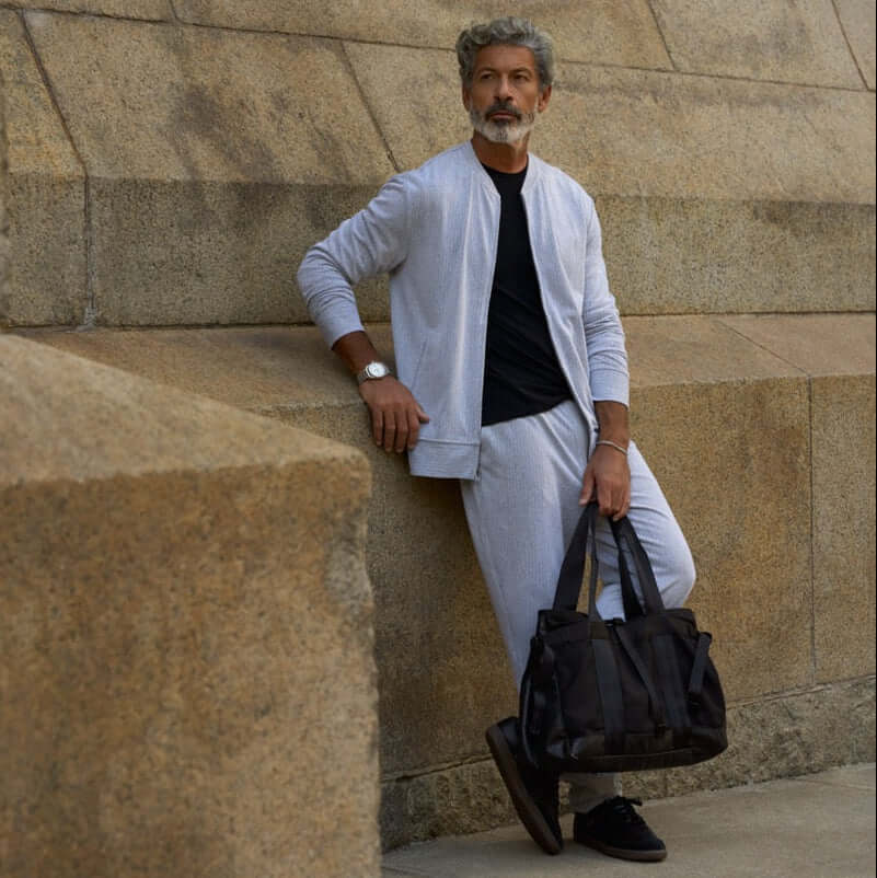 Model wearing Mini Herringbone Bomber Jacket in Natural with matching pants and a bag.