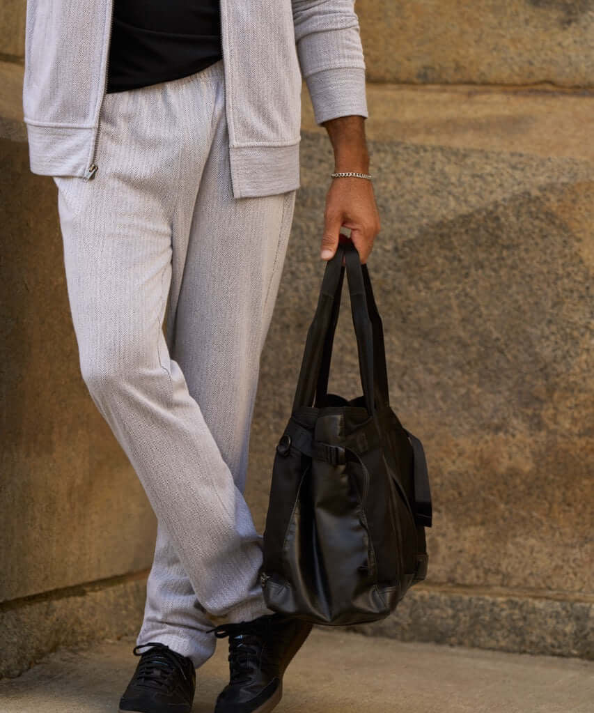 Mini Herringbone Drawstring Pant in Natural worn with a coordinating bomber jacket and a black bag.