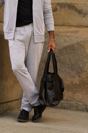 Mini Herringbone Drawstring Pant in Natural worn with a coordinating bomber jacket and a black bag.