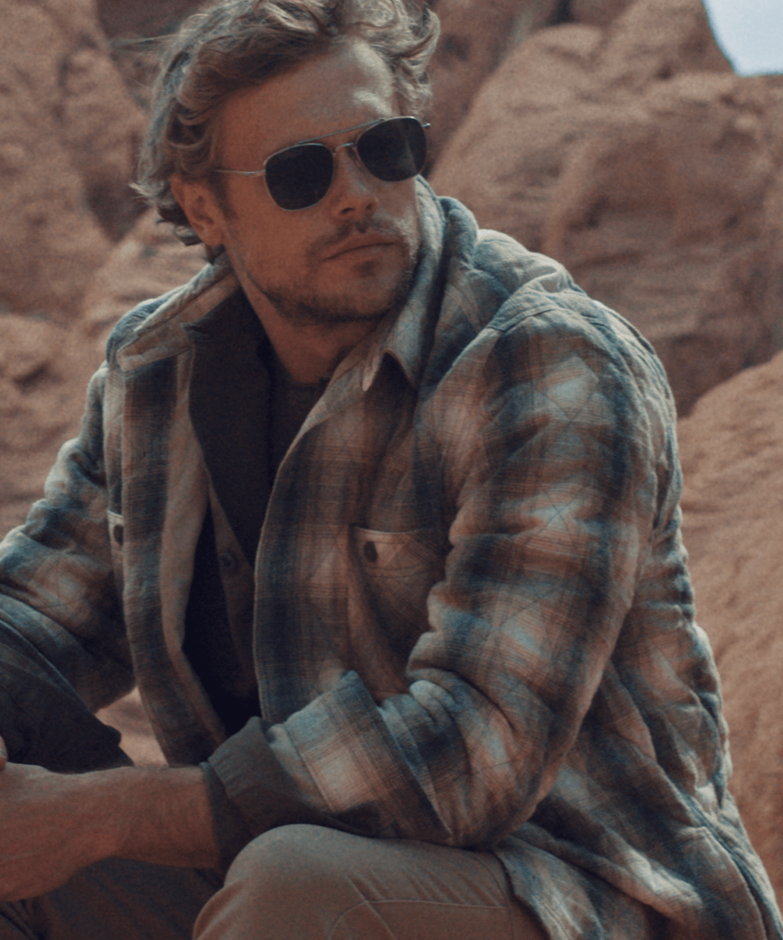 Model wearing a quilted plaid shirt jacket in Kelp Forest, showcasing style and warmth in an outdoor setting.