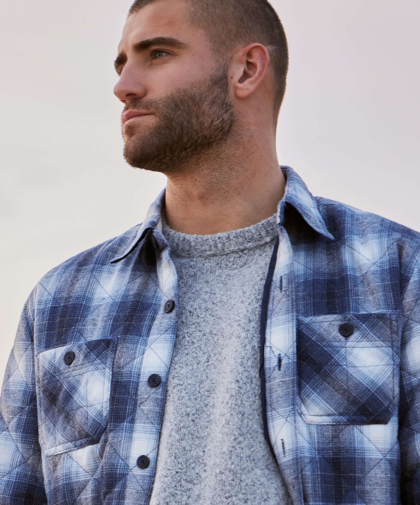 Model wearing a quilted plaid shirt jacket in Quiet Harbor, perfect for winter style and warmth.
