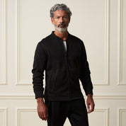 Ribbed Bomber Jacket in Black worn by a model, featuring a zip front and side pockets against a classic backdrop.
