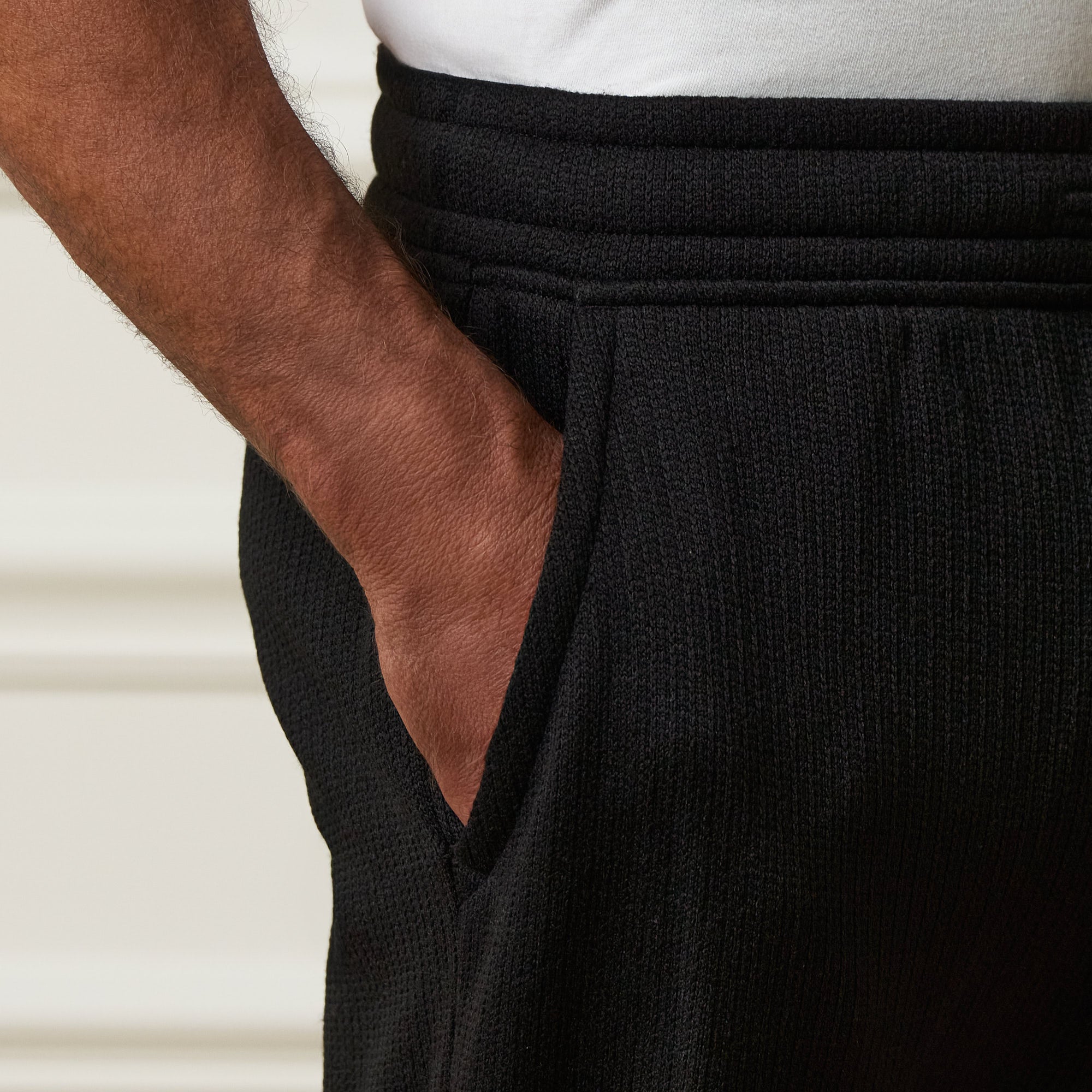 Close-up of the drawstring waistband and side pocket of the Ribbed Drawstring Pant in Black.