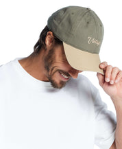 Man wearing an adjustable Script Vintage Hat in Olive, showcasing a stylish and casual look.