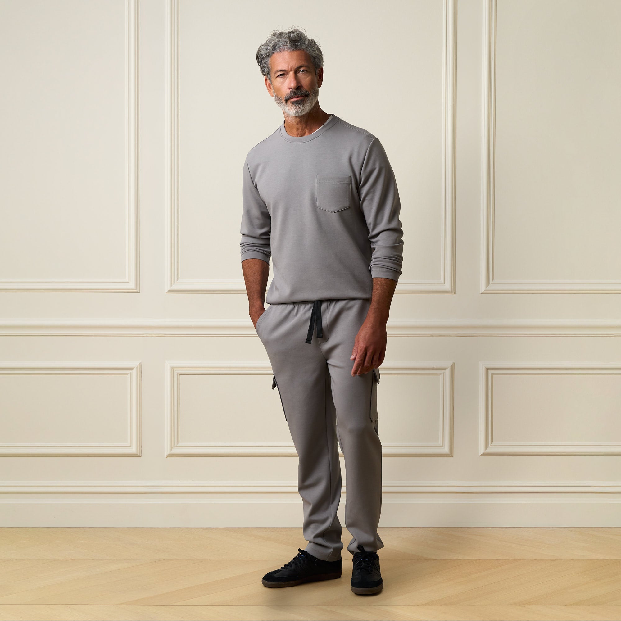 Man wearing Scuba Cargo Jogger in Grey with matching crew neck top in a stylish indoor setting.