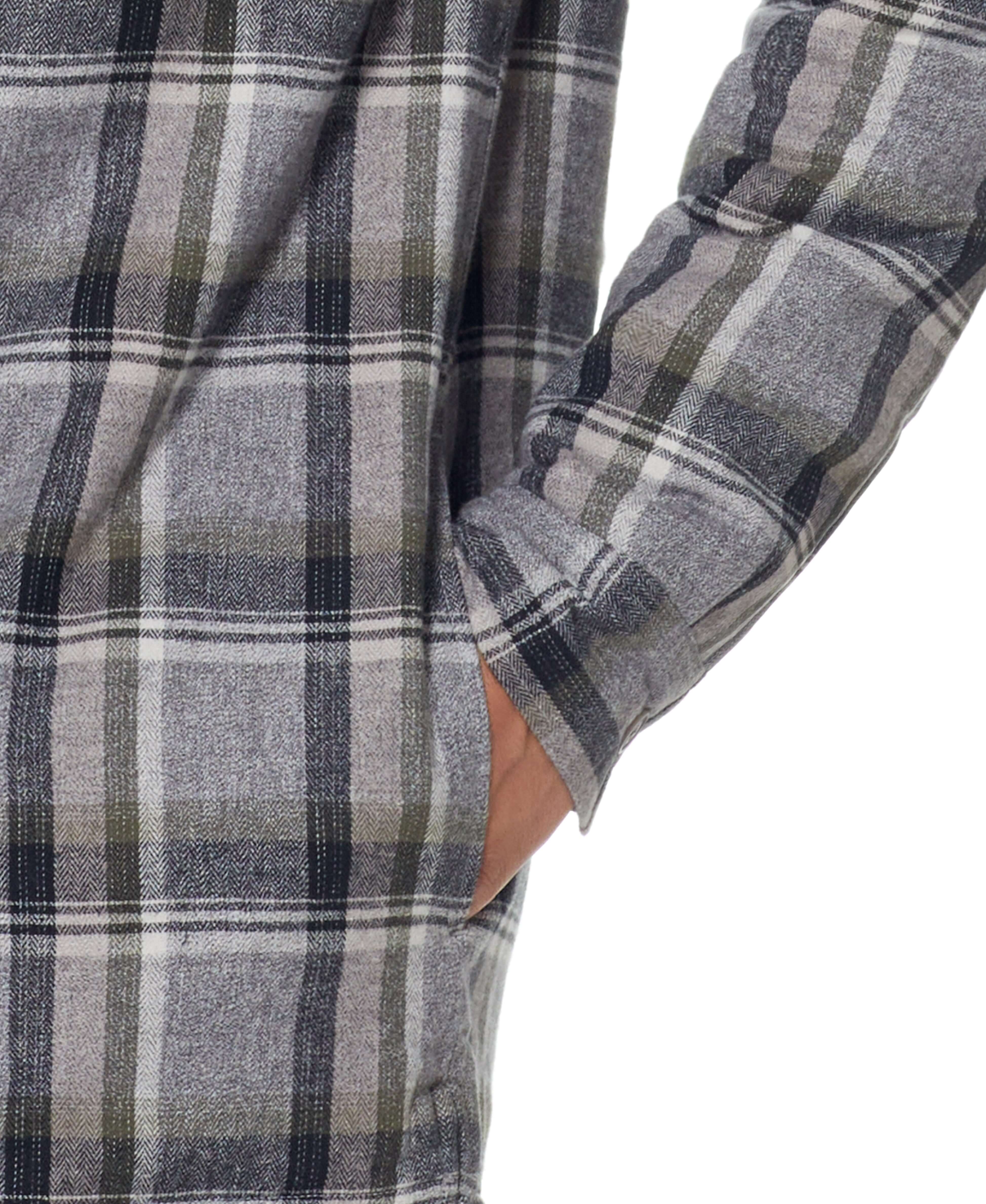 Close-up of a person wearing a Sherpa lined flannel shirt jacket in Twine, featuring a plaid design and side pocket.