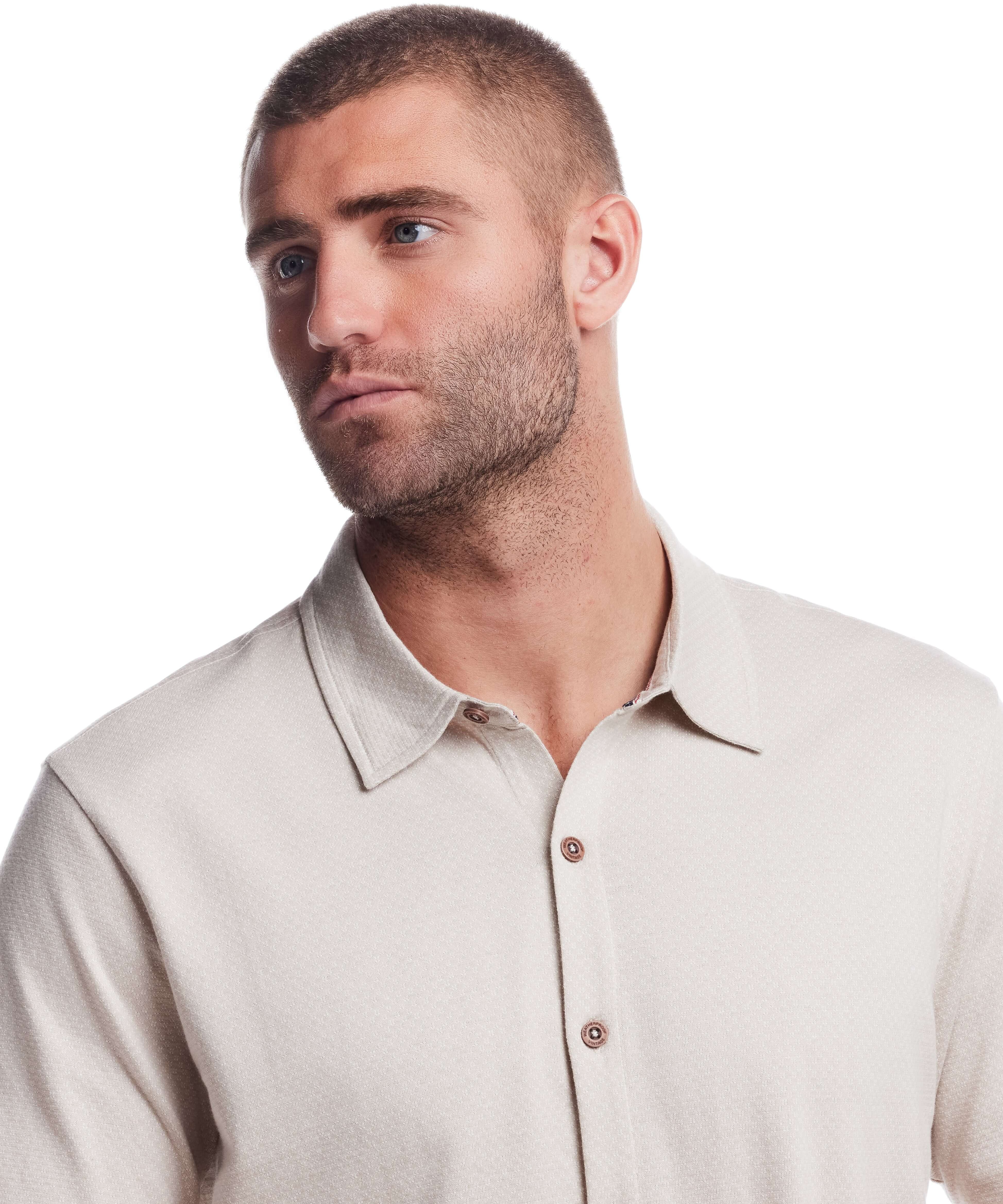 Model wearing a short sleeve button front coat in natural with a textured jacquard pattern and collar.