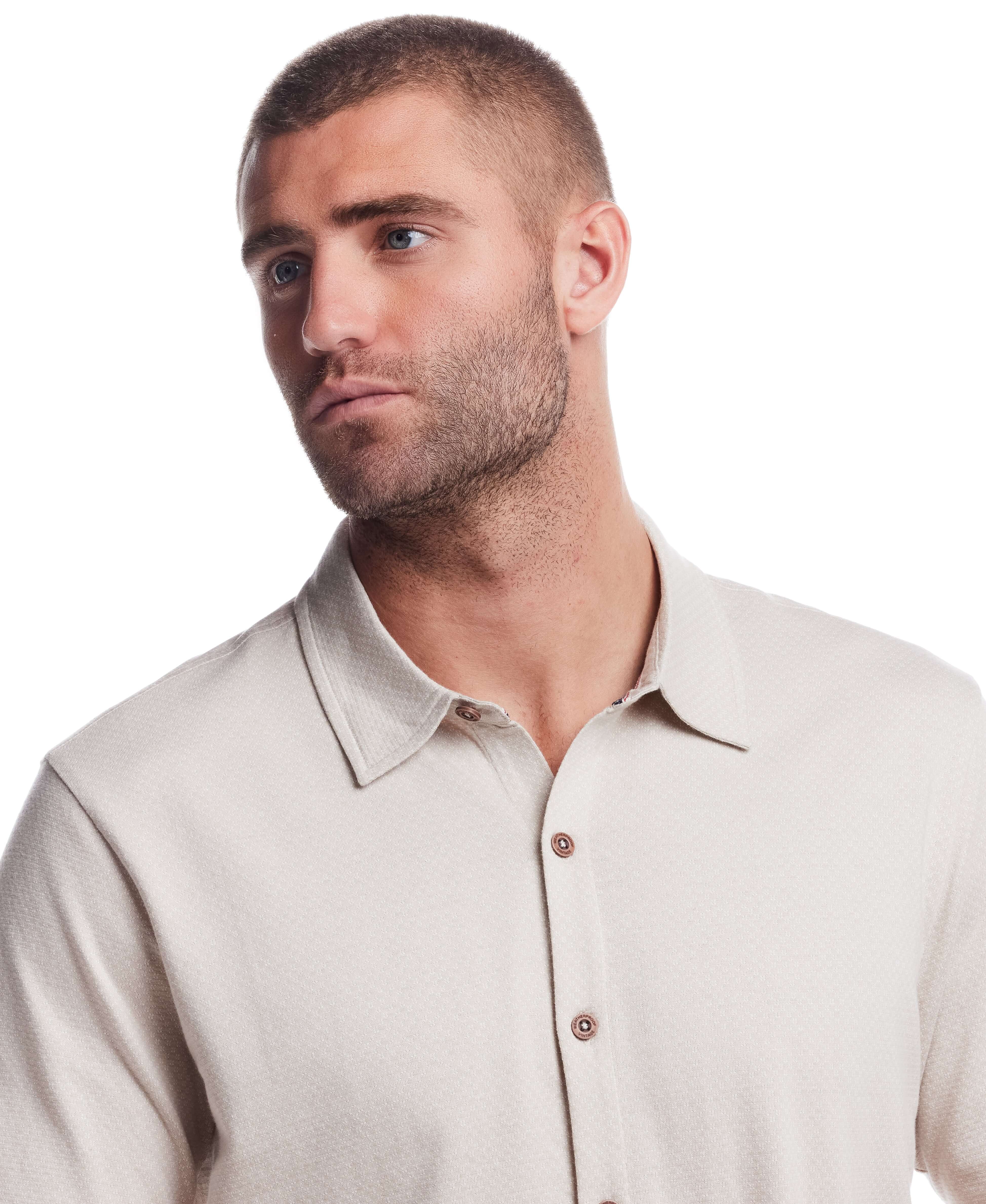 Model wearing a short sleeve button front coat in natural with a textured jacquard pattern and collar.