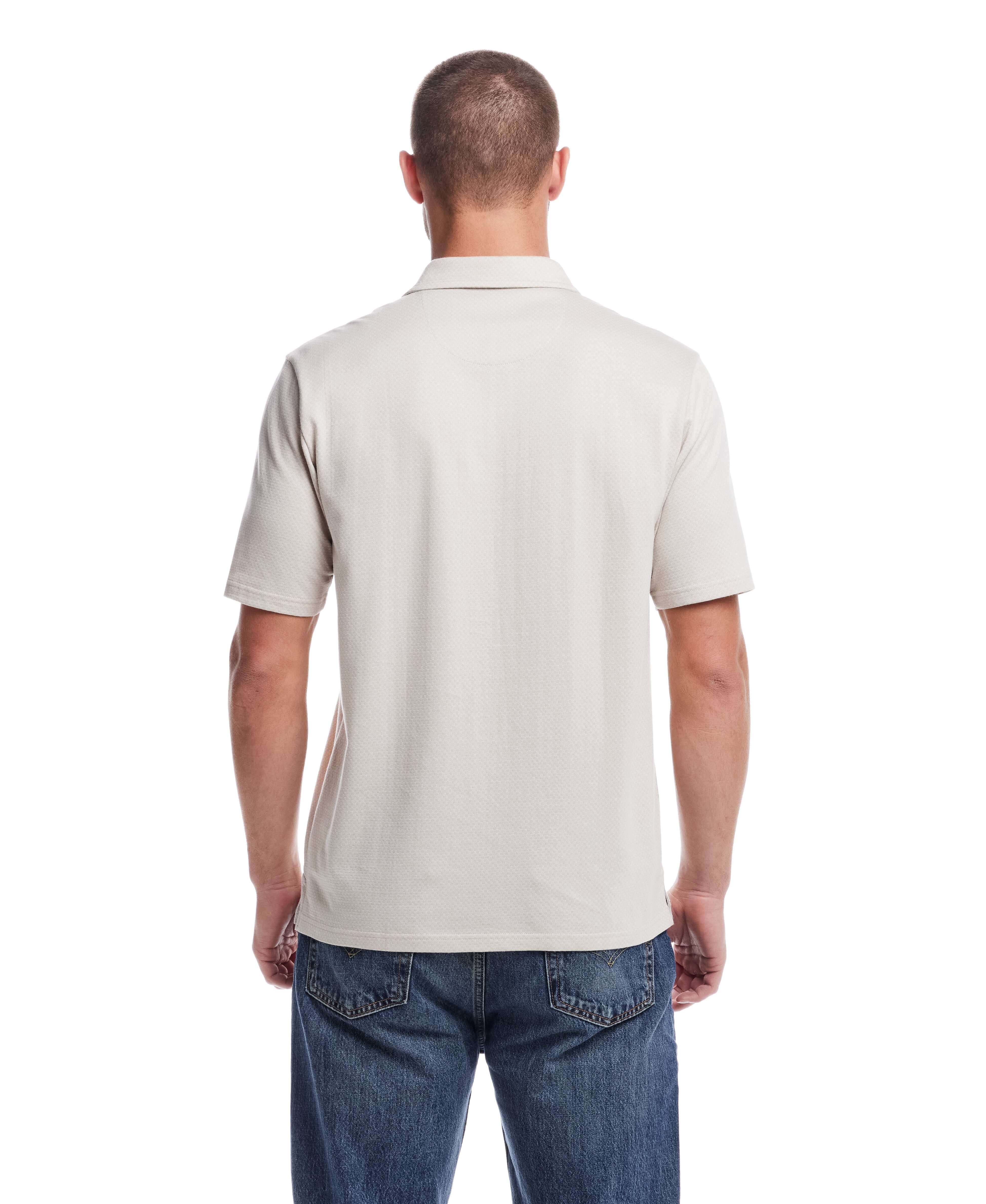 Back view of a man wearing a short sleeve button front coat in natural color, showcasing the minimalist design.