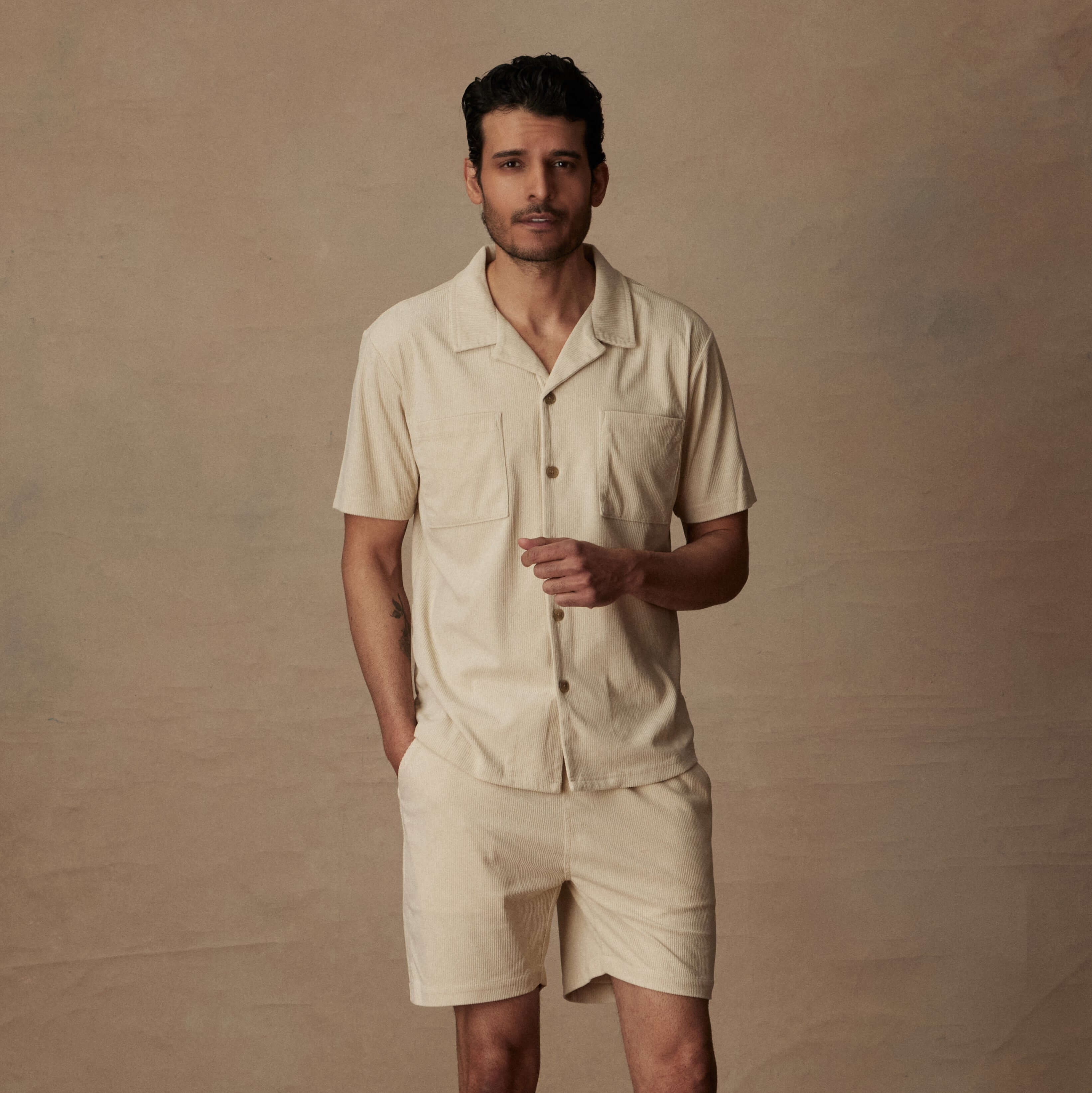 Model wearing a cream short sleeve corduroy cabana shirt with matching shorts, showcasing a classic beach look.