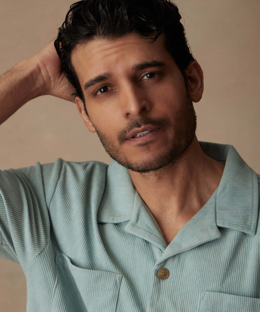 Model wearing a short sleeve teal mist corduroy cabana shirt with a camp collar and double chest pockets.