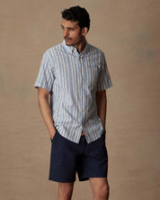 Model wearing a short sleeve faux linen cotton shirt in vista blue, showcasing a classic fit and soft button down collar.