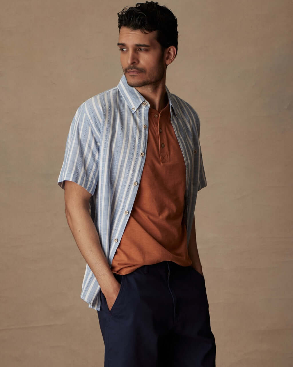 Model wearing a short sleeve faux linen cotton shirt in vista blue with an orange undershirt, showcasing a classic fit.
