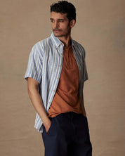 Model wearing a short sleeve faux linen cotton shirt in vista blue with an orange undershirt, showcasing a classic fit.