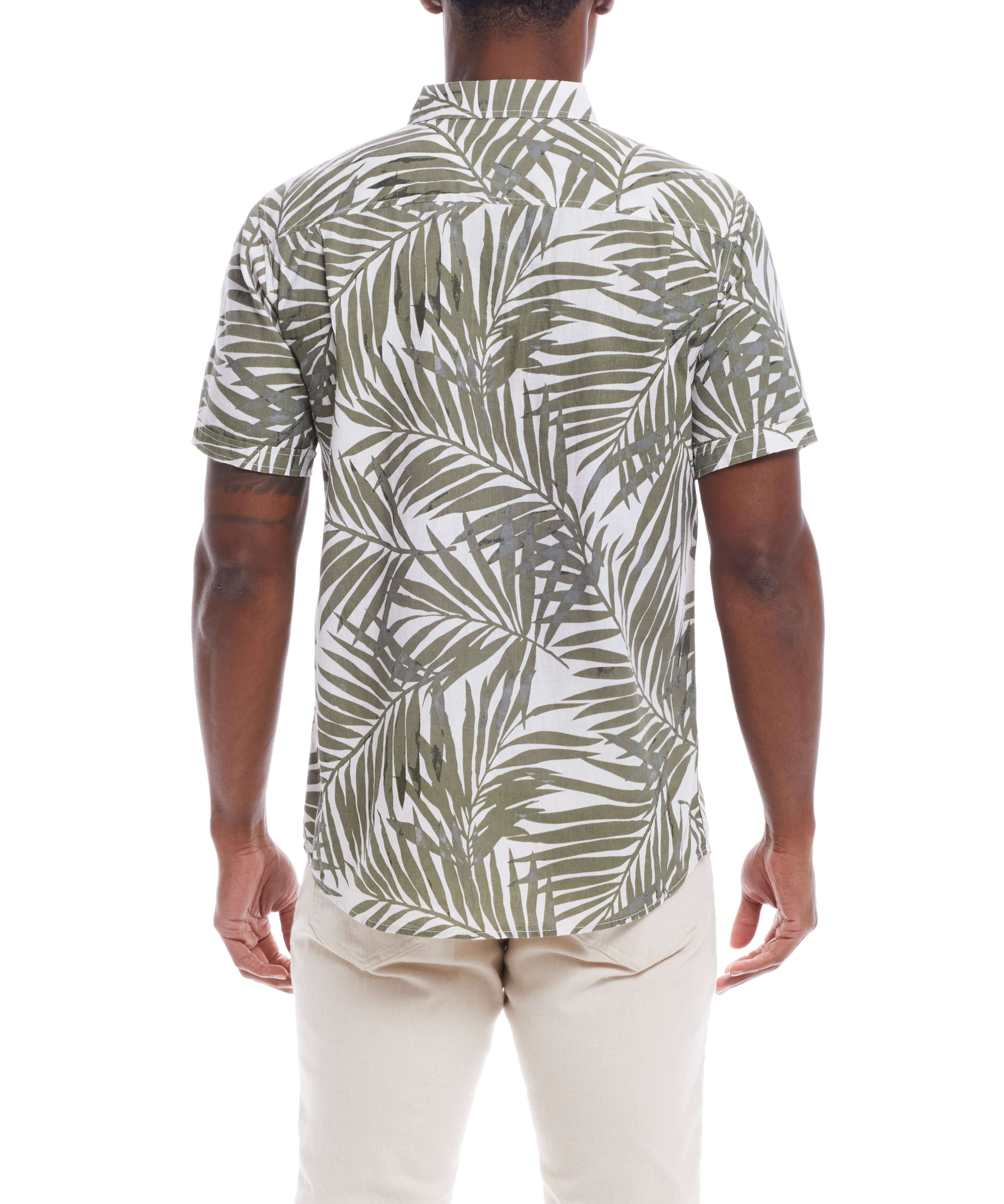 Back view of a man in a short sleeve floral shirt in lichen green, featuring a leafy print, paired with light-colored pants.