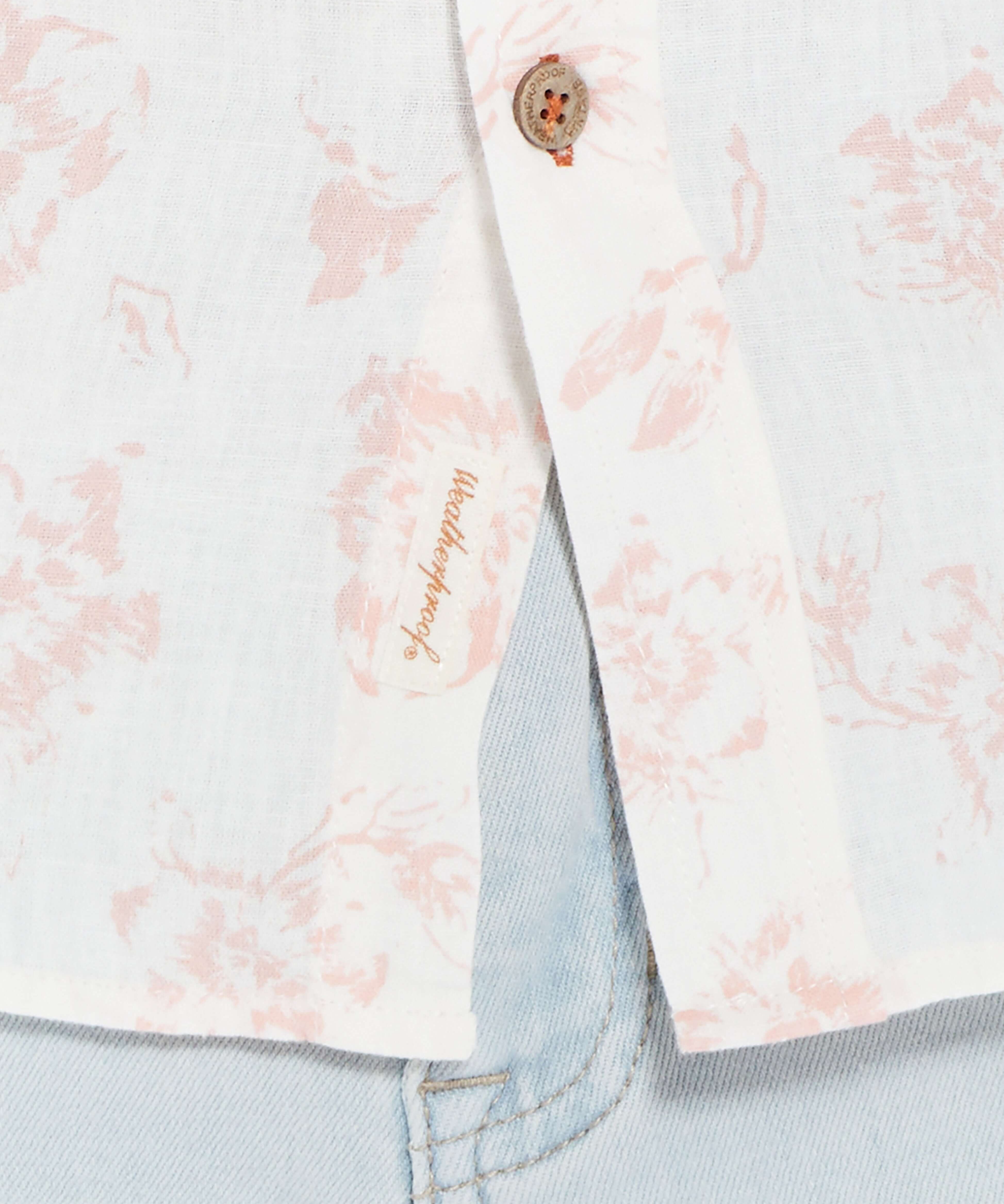 Close-up of a pink floral print short sleeve button-down shirt showcasing linen cotton fabric and button detail.