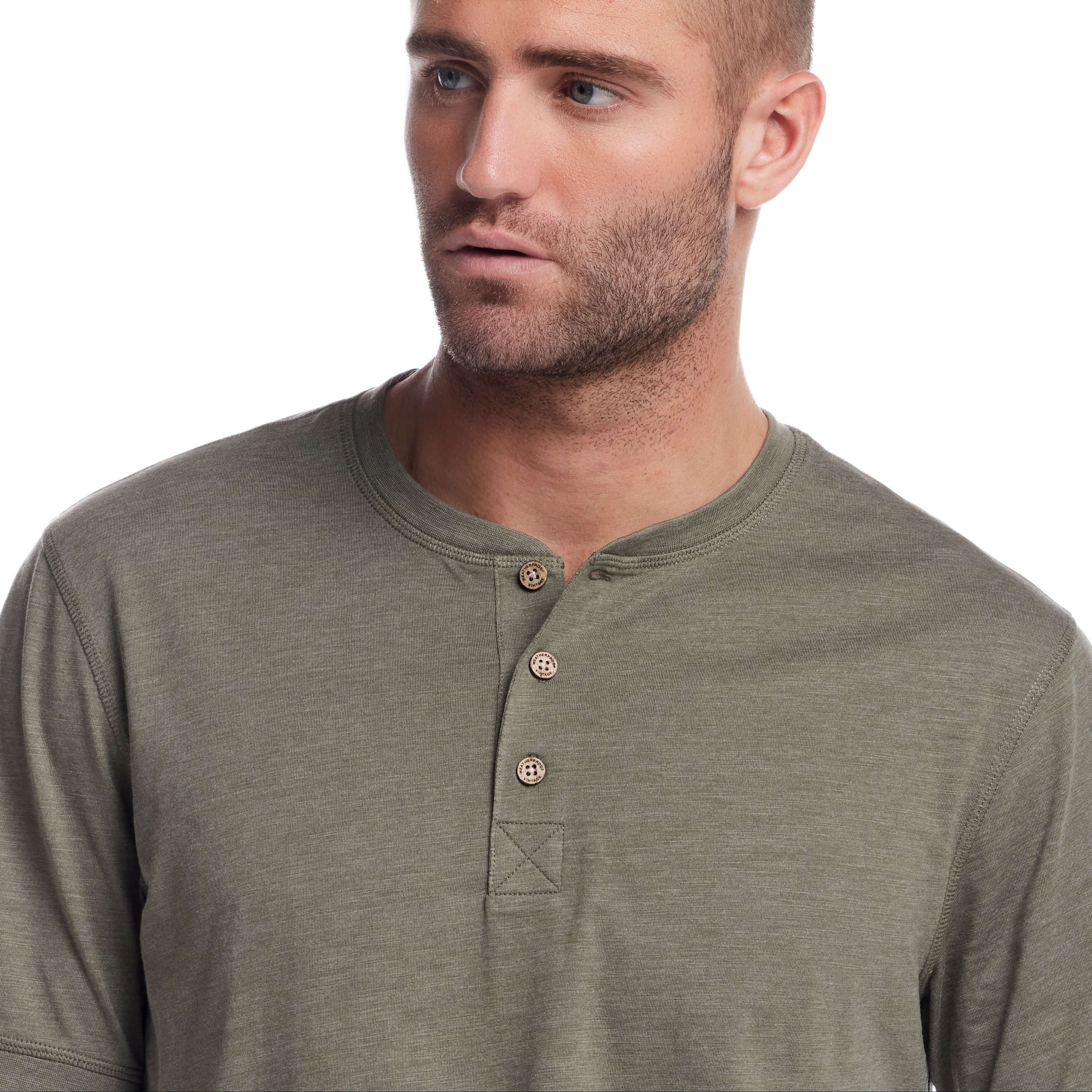 Close-up of a man wearing a short sleeve melange henley shirt in olive, featuring a three-button placket and rib-knit neck.