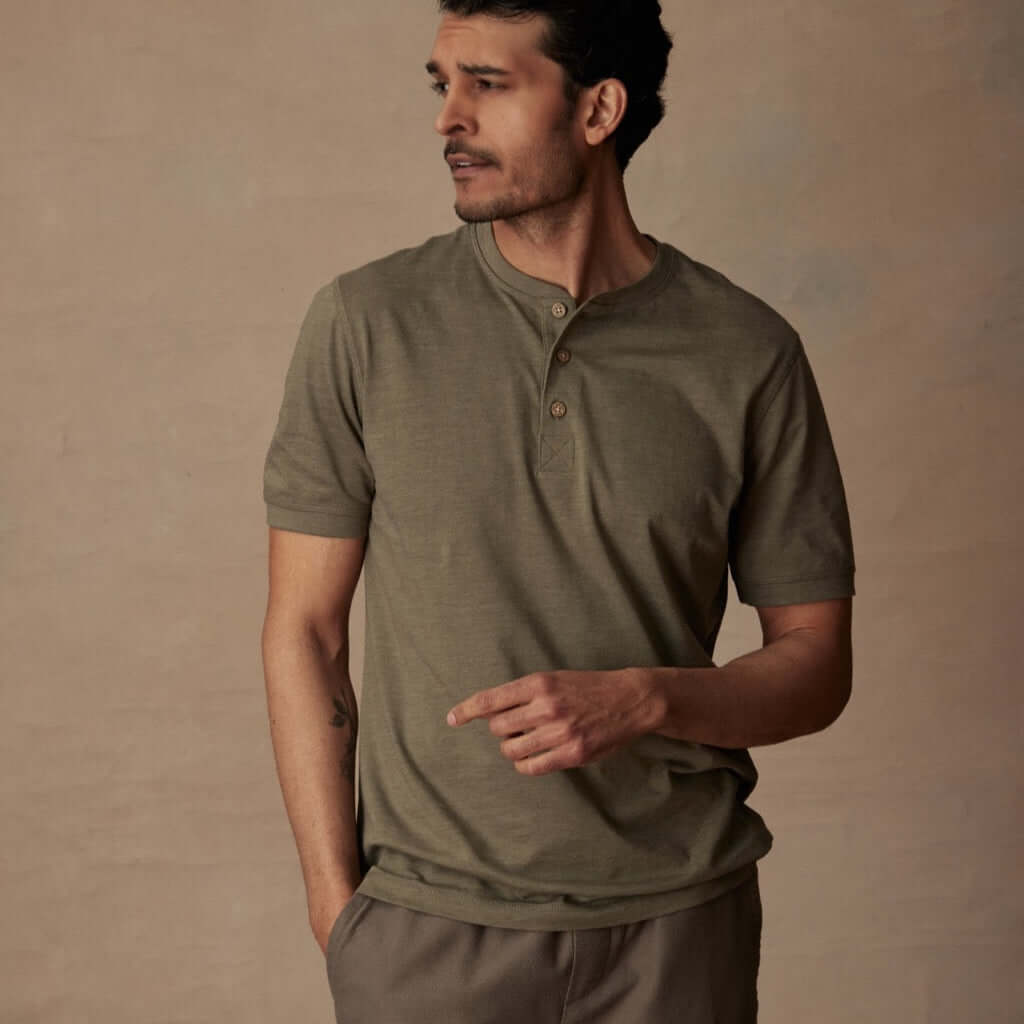 Man wearing a short sleeve melange henley shirt in olive green, showcasing a classic fit and rib-knit detailing.