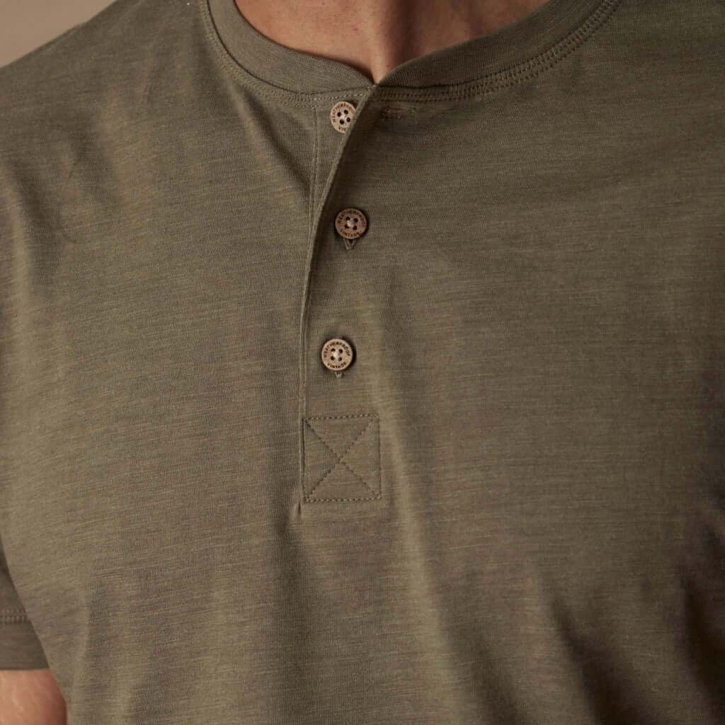 Close-up of a short sleeve melange henley shirt in olive with a 3-button placket and ribbed neckline.