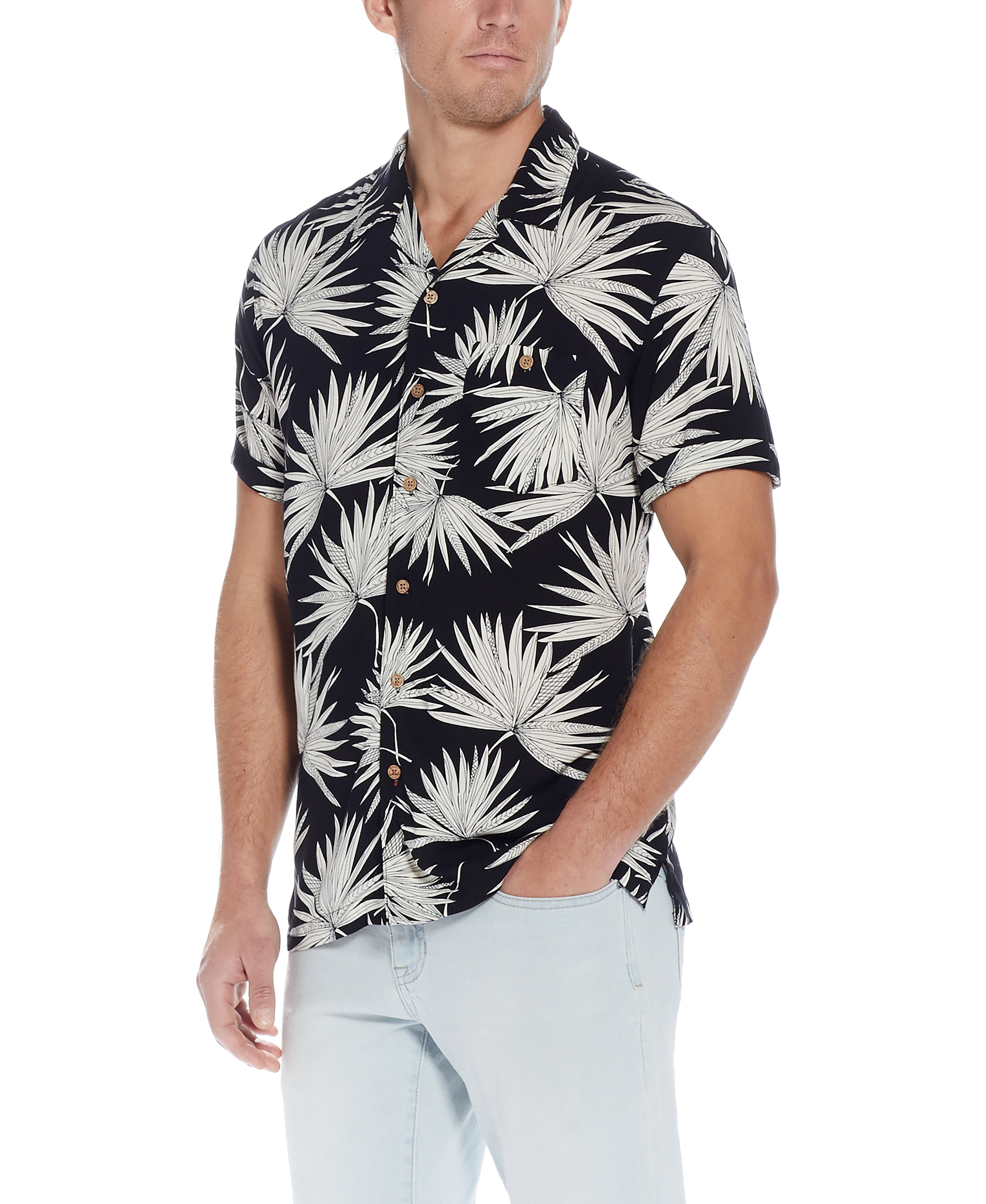 Short Sleeve Rayon Print Camp Collar In Sky Captain worn by a man, featuring a vibrant palm leaf design and button down front.