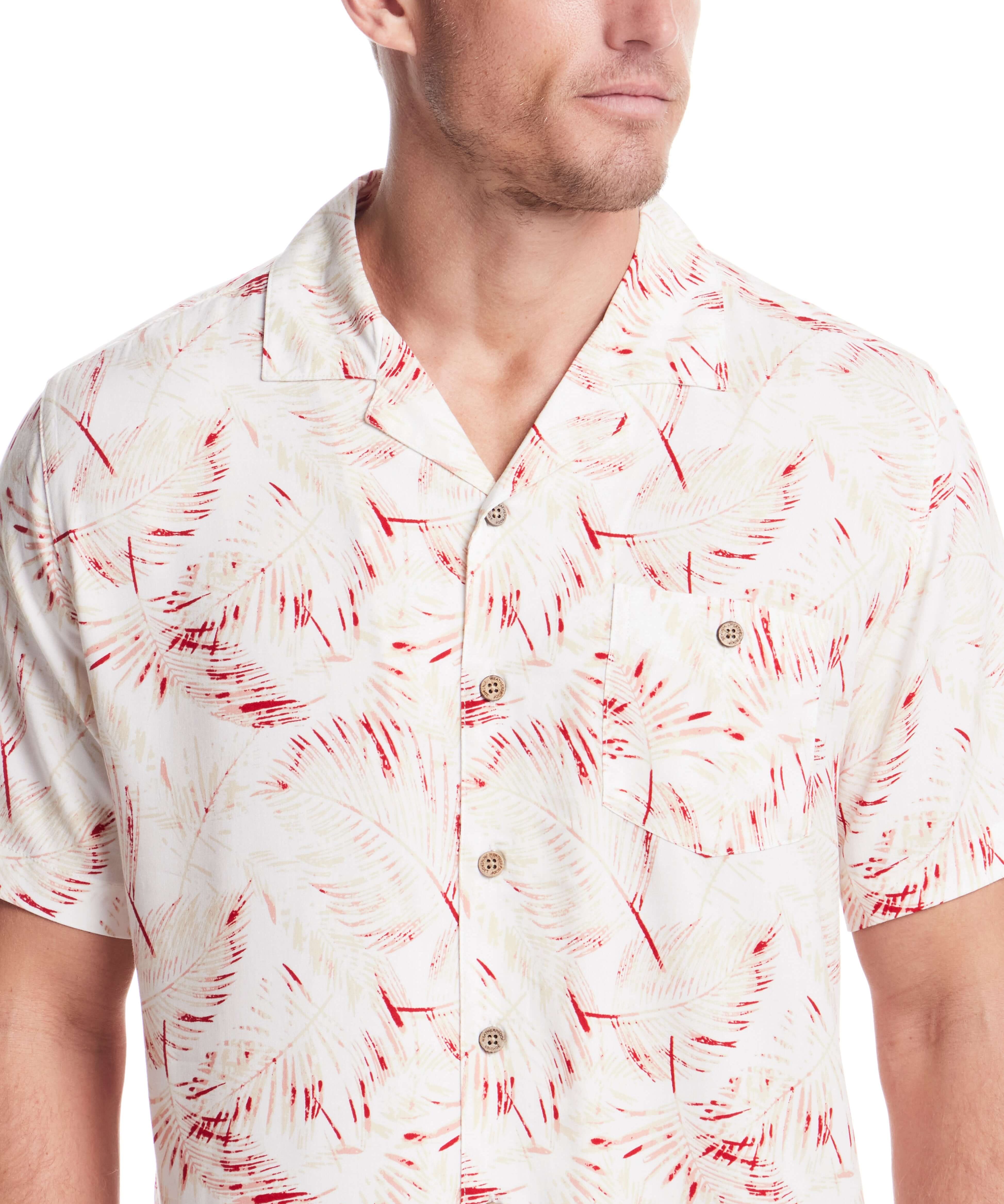 Model wearing a short sleeve rayon printed camp shirt in dusty pink with retro pattern and camp collar.