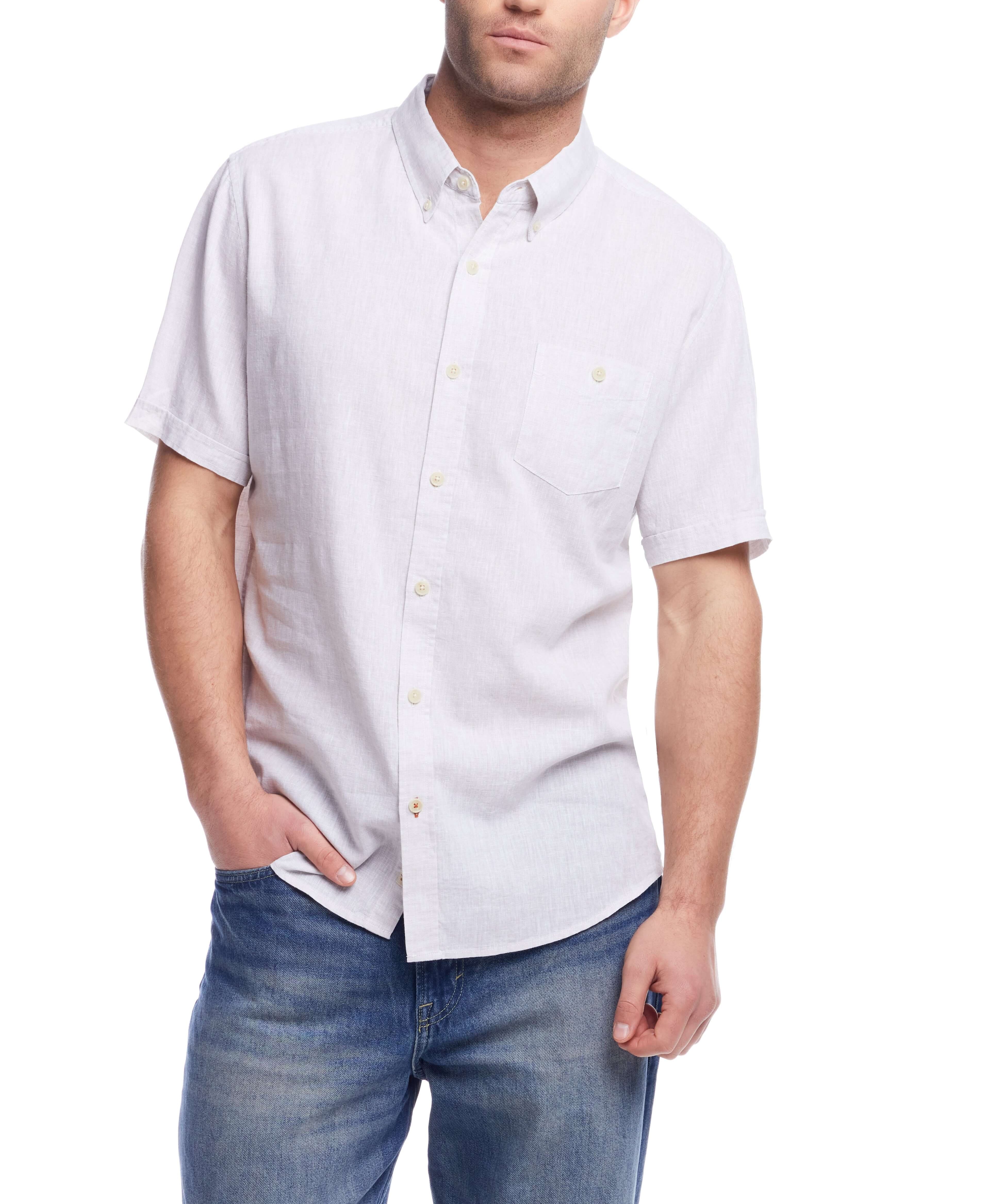 Man wearing a short sleeve solid linen cotton shirt in natural color, paired with blue jeans for a casual look.