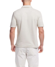 Back view of a man wearing a short sleeve twill polo shirt in natural color, featuring a classic design and regular fit.