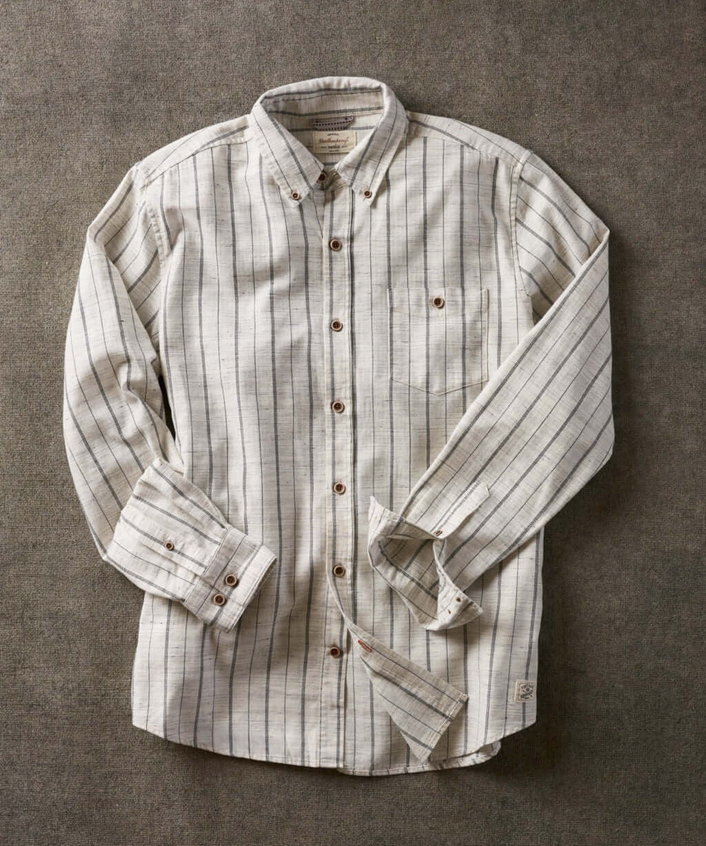 Long sleeve ecru textured shirt featuring subtle stripes, button-down collar, and chest pocket.