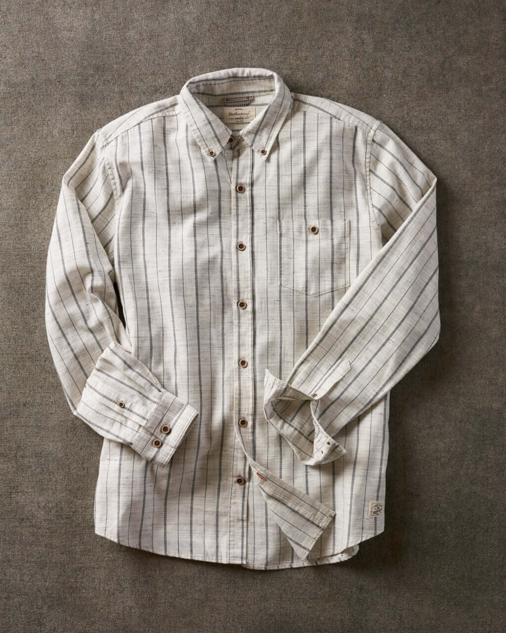 Long sleeve ecru textured shirt featuring subtle stripes, button-down collar, and chest pocket.