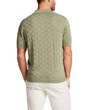 Back view of a man wearing the Stonewash Diamond Sweater Polo in Sea Grass, showcasing the subtle diamond knit texture.