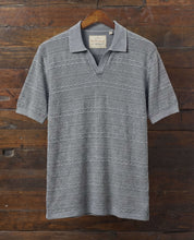 Stonewash Knit Johnny Collar Polo in Flint displayed on a wooden hanger against a rustic background.