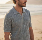 Stonewash Knit Johnny Collar Polo in Flint model on the beach, showcasing a textured knit design.