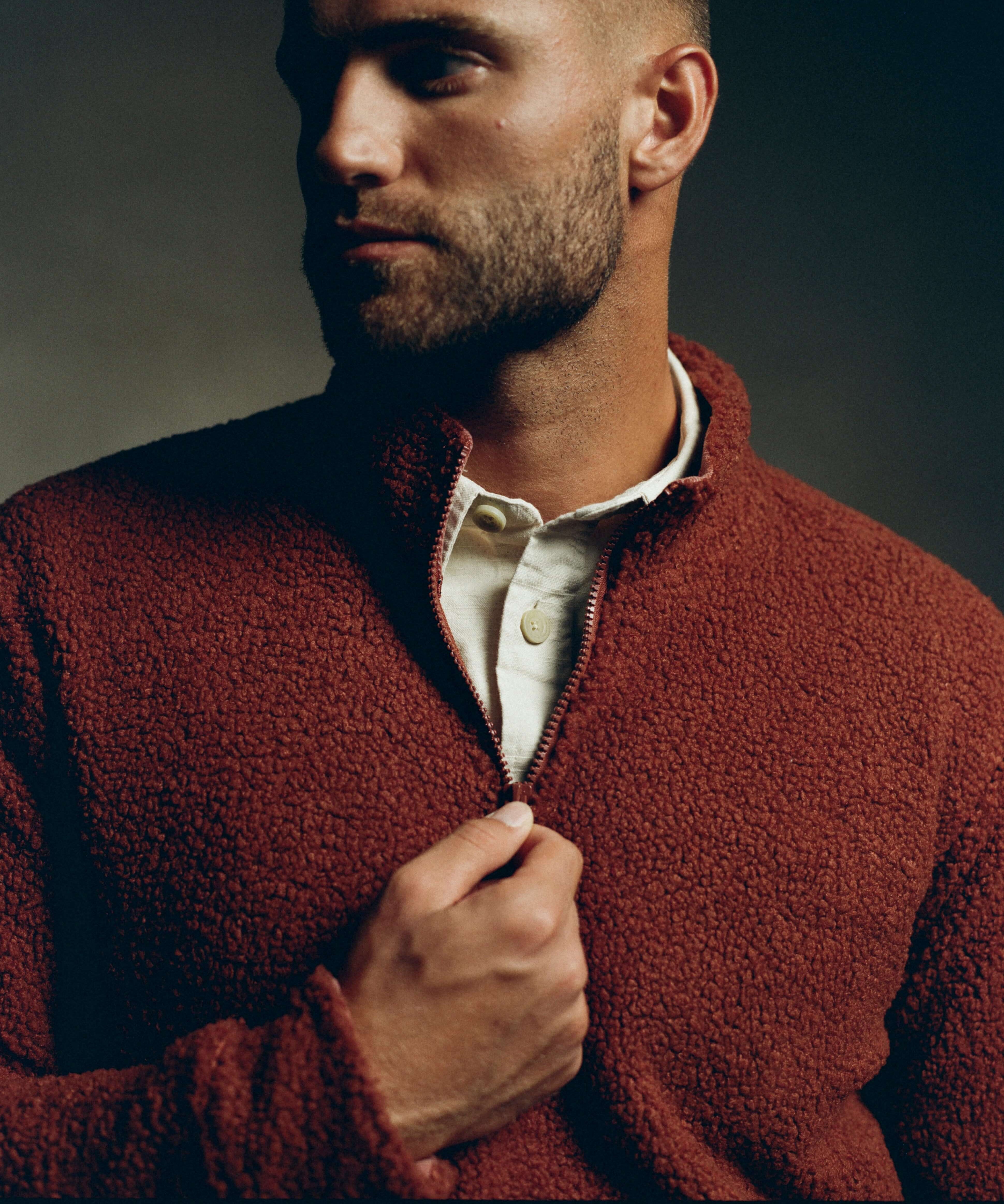 Man in roasted russet teddy sherpa pullover with quarter-zip, showcasing plush fleece and cozy design.