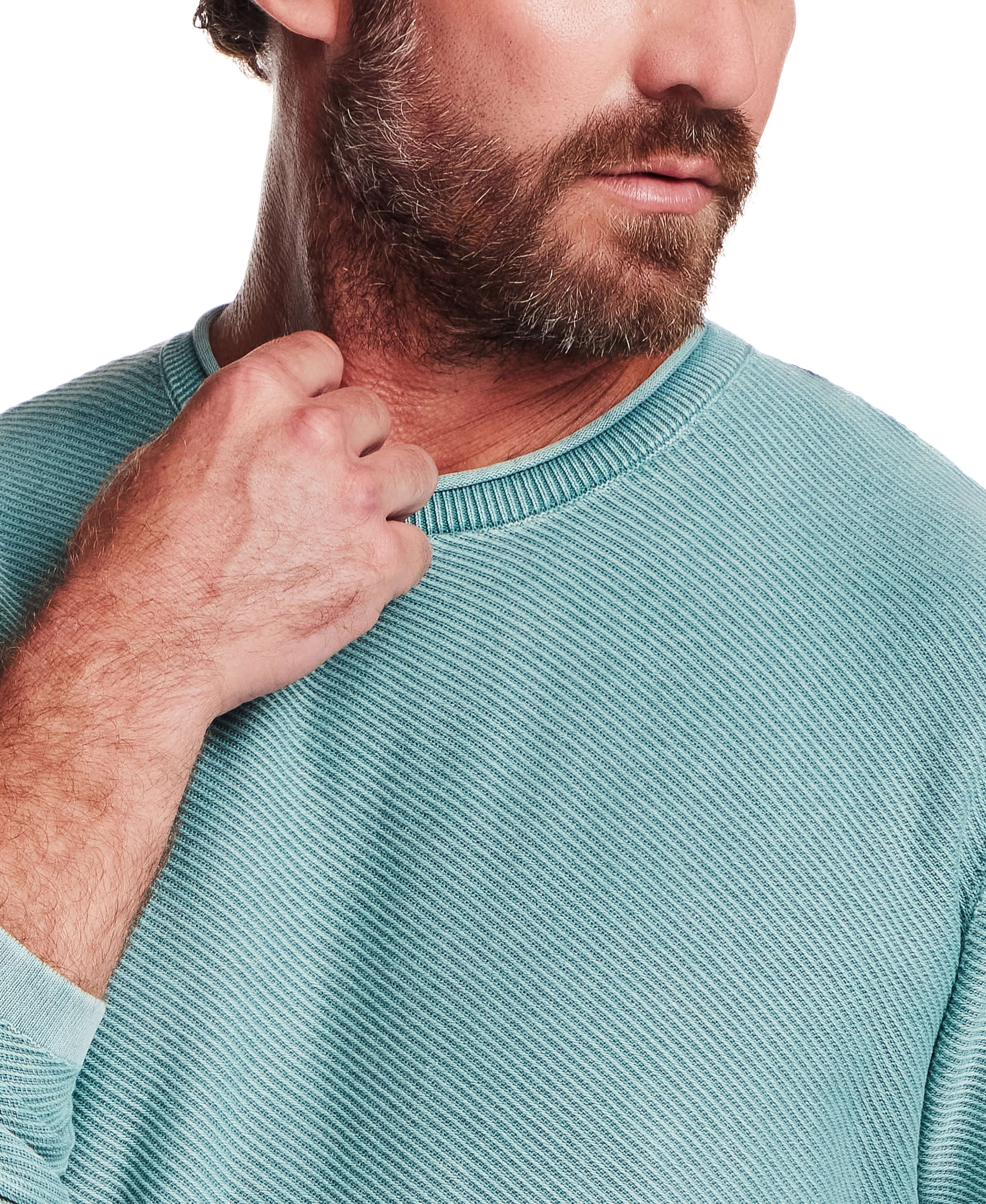 Close-up of a man wearing the Twill Stonewash Sweater in Adriatic Blue, showcasing its soft twill texture.