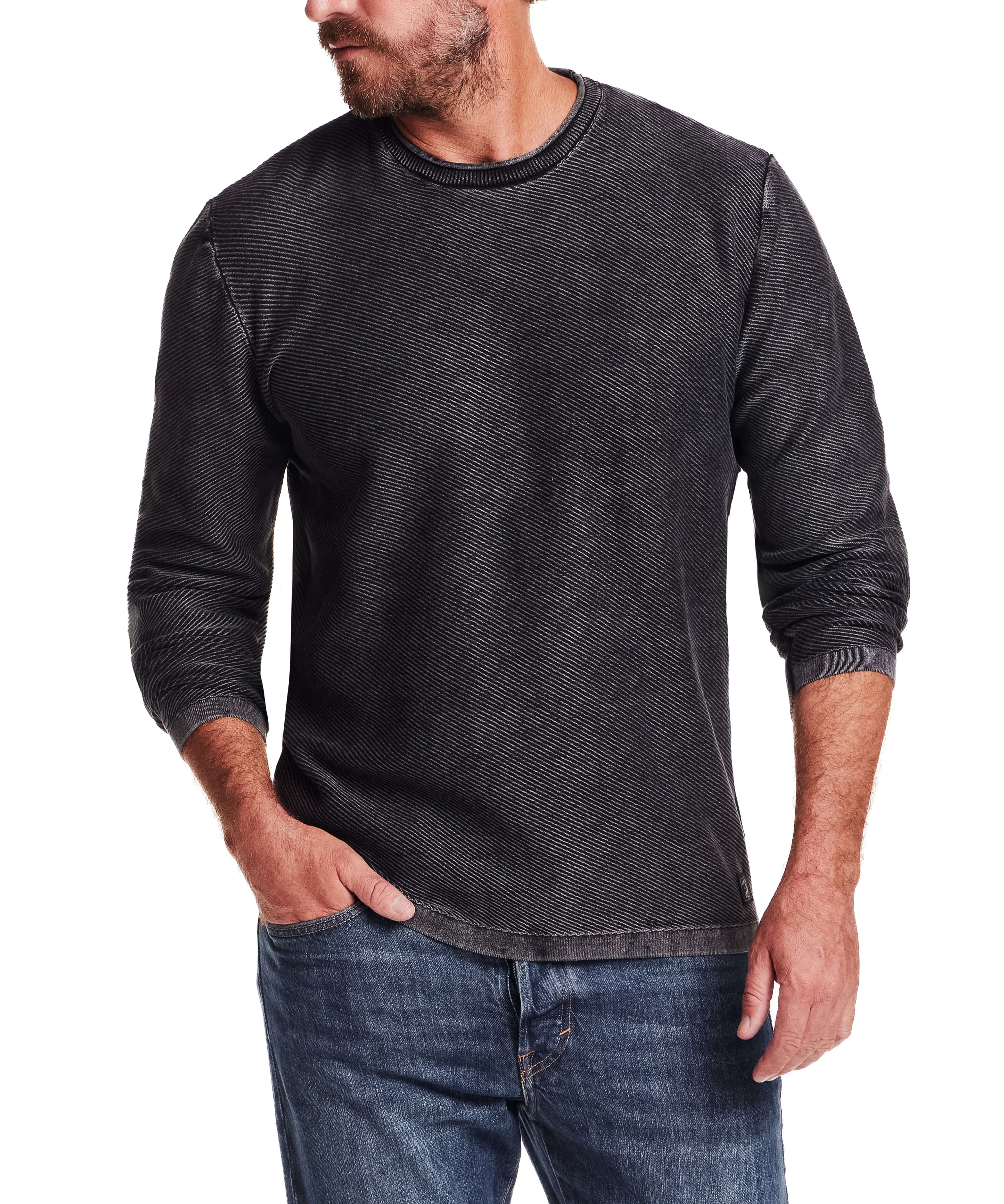 Stylish man wearing a Twill Stonewash Sweater in Jet Black, featuring a classic crew neck and ribbed detail.
