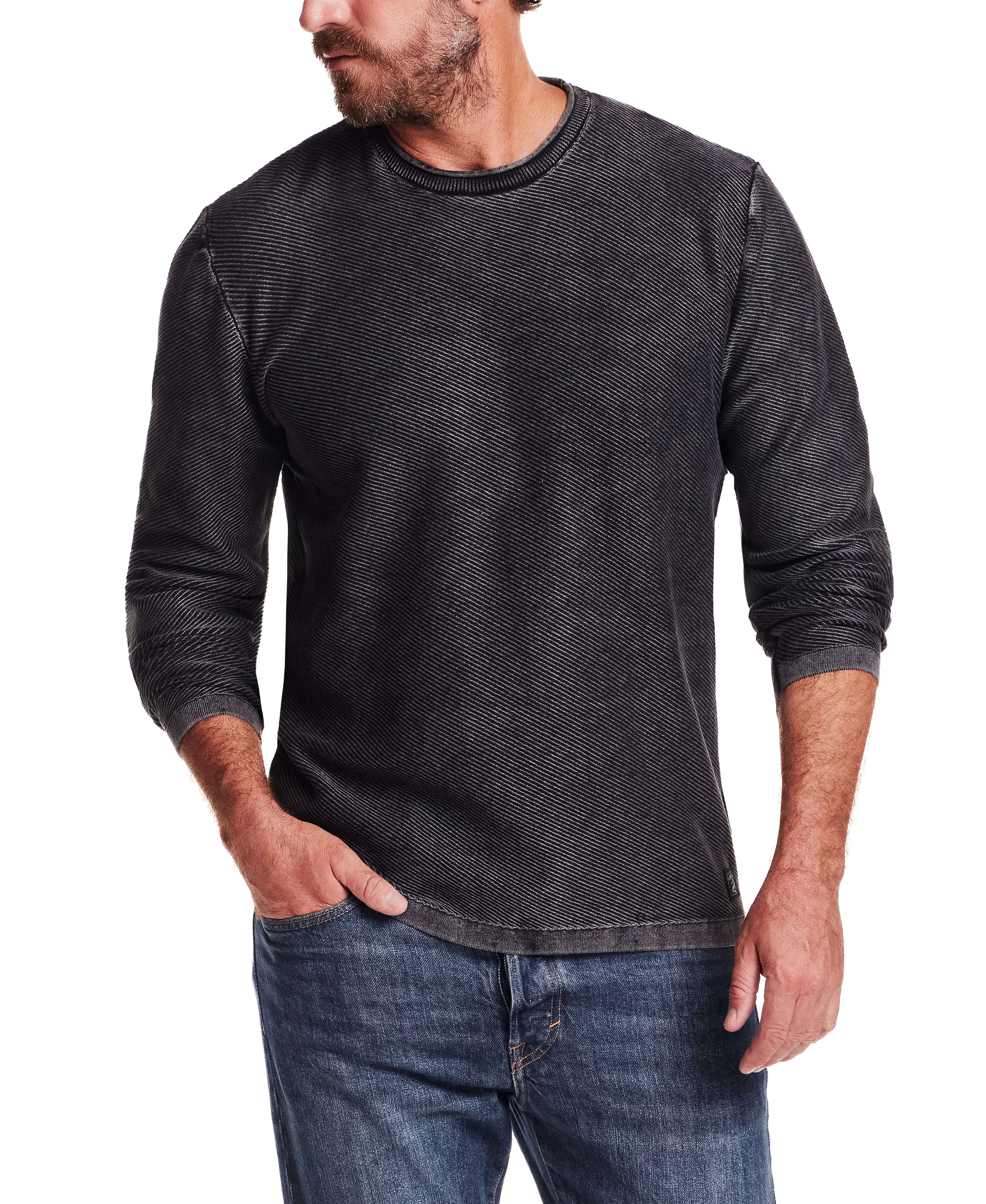 Stylish man wearing a Twill Stonewash Sweater in Jet Black, featuring a classic crew neck and ribbed detail.