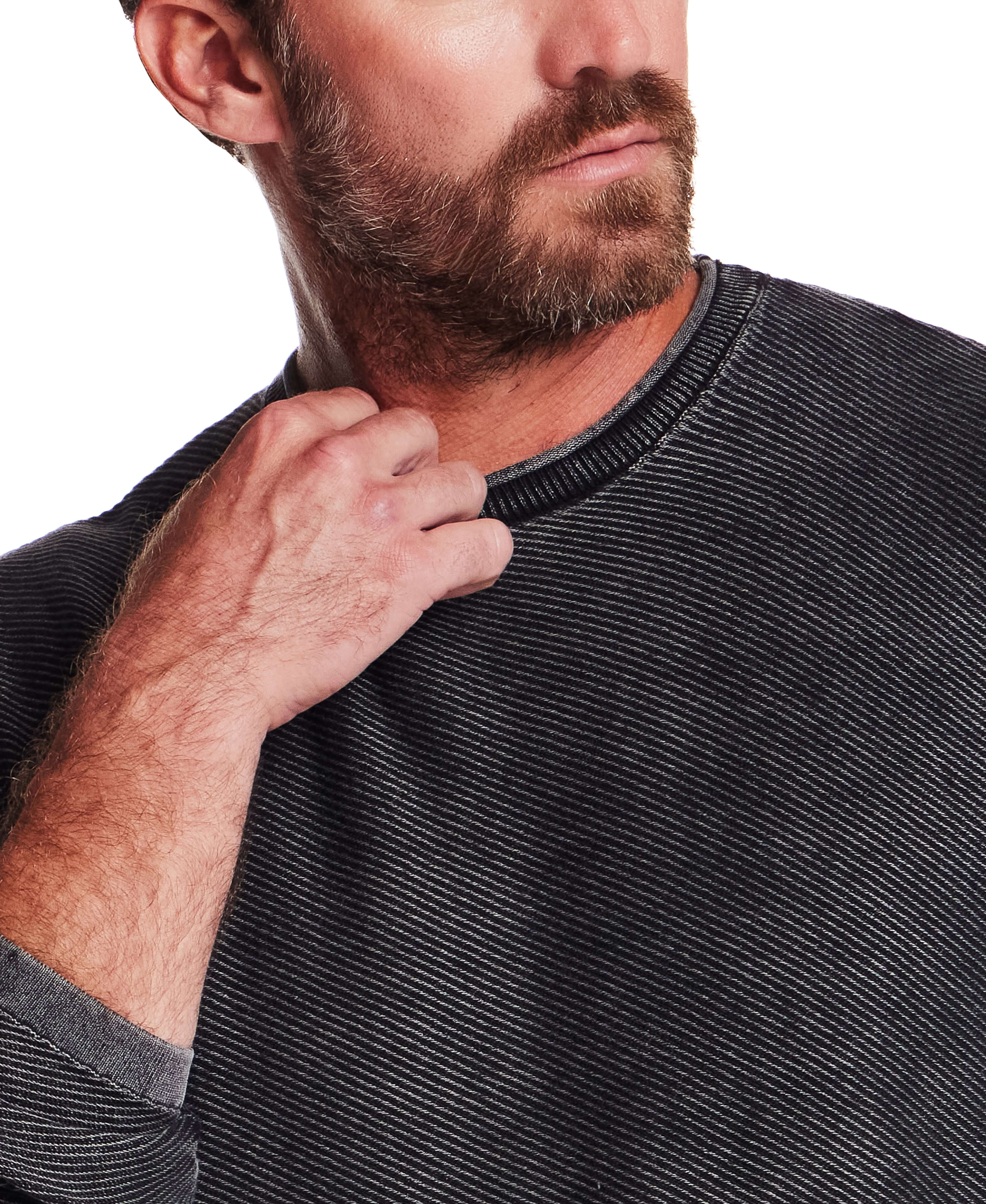 Close-up of a man wearing the Twill Stonewash Sweater in Jet Black, showcasing its ribbed neckline and textured fabric.