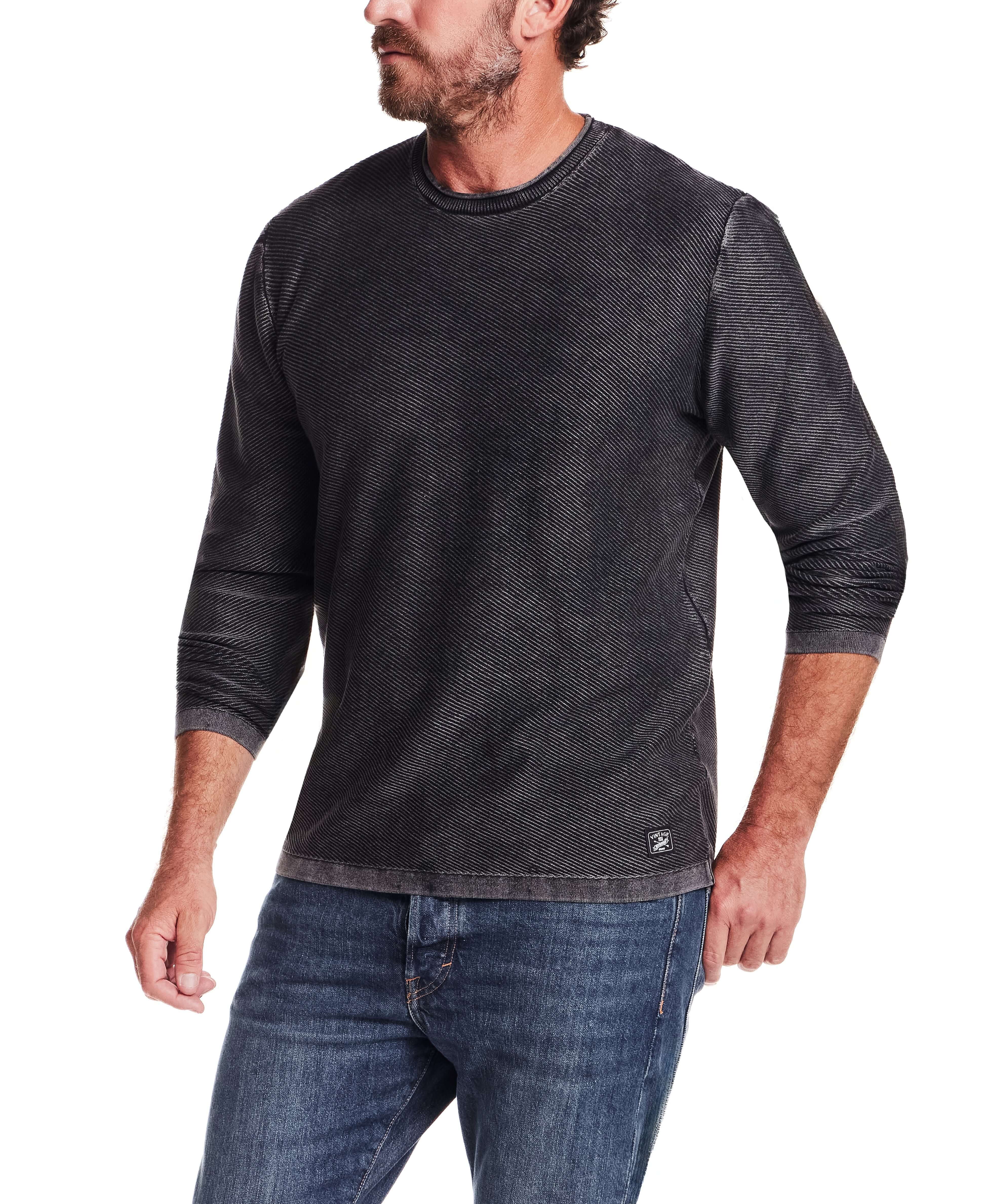 Twill Stonewash Sweater in Jet Black worn by a man, showcasing its classic roll-neck design and texture.
